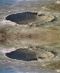 Dieses Bild zeigt einen Meteor-Krater in Arizona. Dass es sich um eine Mulde und nicht um einen Hügel handelt, schließen wir aus dem von oben einfallenden Licht. Dreht man das Bild um, wird die Zuordnung etwas schwieriger. © Lunar and Planetary Institute 